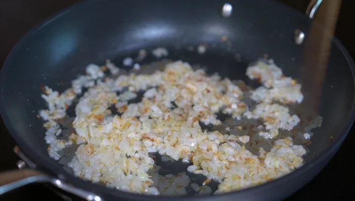Add chopped garlic, oregano, and pepper. Stir and cook for 1 minute to prevent burning.