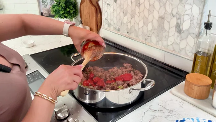 Pour in 4 tablespoons of tomato sauce and 3 cups of beef broth (or water).