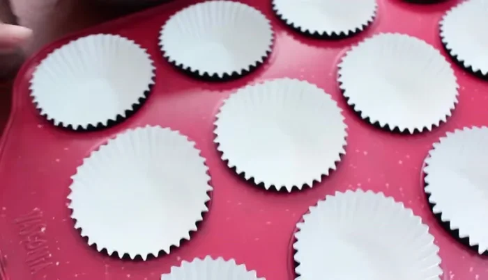 Preheat oven to 200°C (392°F). Fill cupcake liners about ¾ full with batter. Tap the tray to remove air bubbles. Add chopped walnuts (optional) to the top.