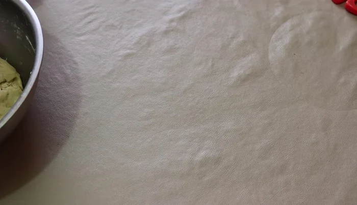 On a floured surface, roll out half of the dough. Place the cooled pineapple filling in the center.