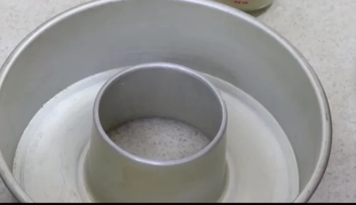 Prepare the baking mold by greasing it with a mixture of vegetable shortening and flour.