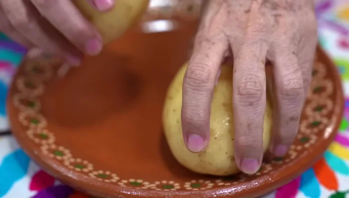 Prepare potatoes: Cut potatoes into cubes and keep them in water to prevent discoloration. Sauté with half an onion and salt.