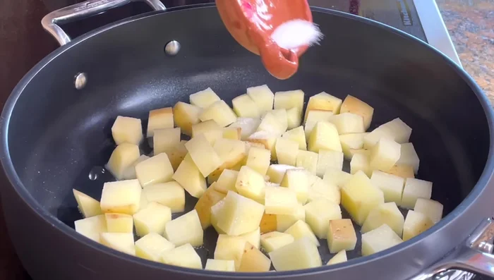 Cook potatoes: In hot oil, sauté potato cubes with salt for 5-6 minutes. Add chopped onion and sauté for another 5 minutes. Pour in the prepared sauce, season with salt, cover and cook for 15 minutes.