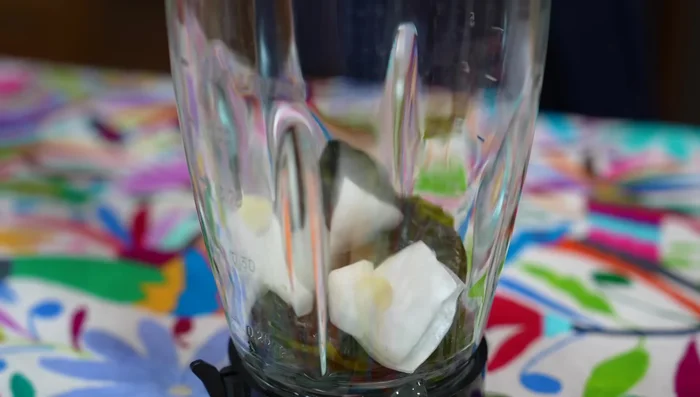 Blend the whole poblano chilies, onion, garlic, chicken broth, cilantro, water, and cream until smooth.