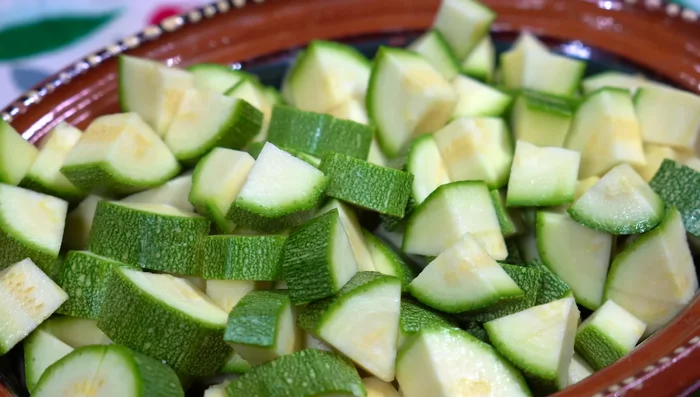 Prepare the zucchini by removing the ends and cutting into cubes. Chop the onion, garlic, and serrano chili.