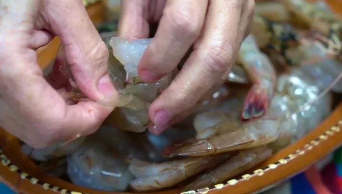 Clean the shrimp: remove shells and digestive tract using a toothpick. Cut into pieces and add salt.