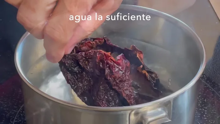 In a pot, add the ancho chili to hot water. After a couple of minutes, turn off the heat and let it hydrate.