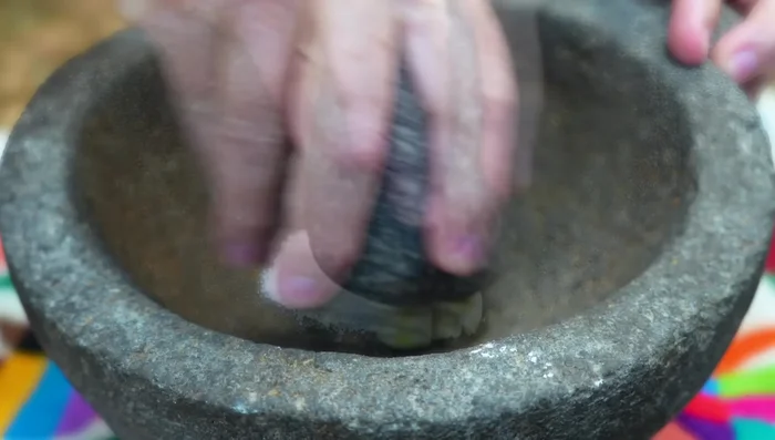 In a molcajete (or blender), grind garlic with salt, then add allspice, cumin, oregano, and a clove of garlic.