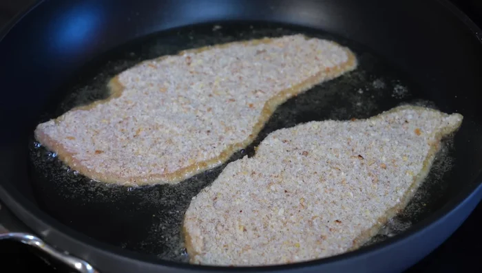 Fry breaded chicken breasts until golden brown.
