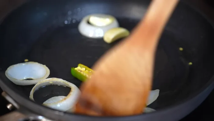 Add chiles de árbol and guajillo chilies (cut into pieces). Stir constantly to prevent burning. Add diced tomatoes.