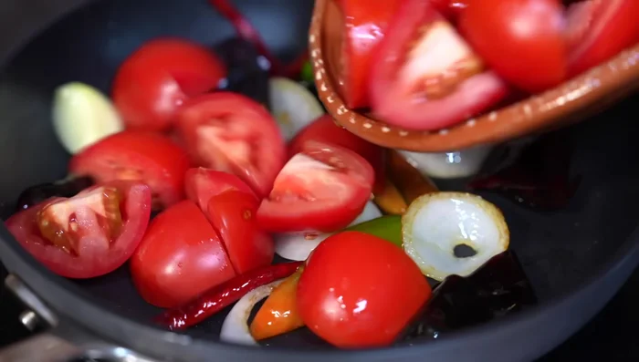 Once the chiles release their aroma, add the tomatoes. Cook for 5 minutes under medium heat, then add chicken broth. Cover and simmer for 10 minutes.