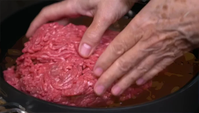 In a hot pan with little oil, fry the ground beef, seasoning with salt and pepper. Add chopped garlic.