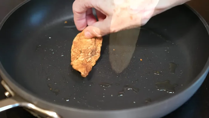 Fry chipotle chiles until hydrated. Add ancho chiles and fry until evenly cooked.
