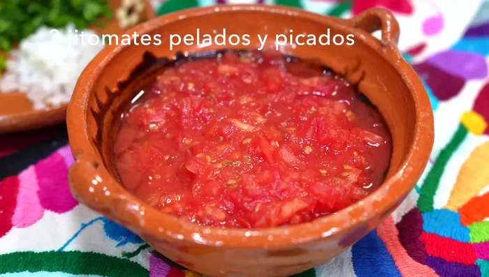 Prepare the sauce: Combine chopped tomatoes, onion, serrano pepper, cilantro, salt, vinegar, and pickled chiles (optional). Mix well.