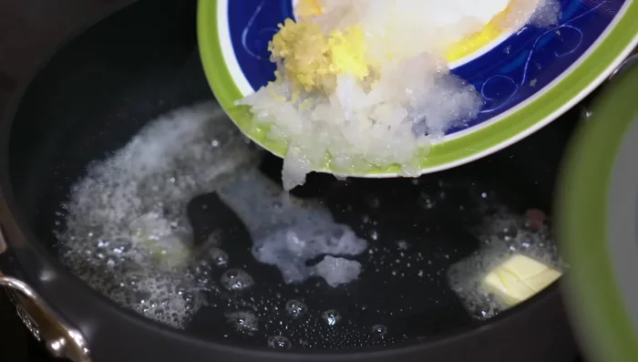 Melt butter in the same pan. Sauté grated onion and garlic until slightly golden.