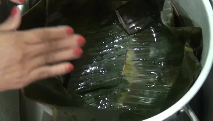 Place a rack in a pot, line it with banana leaves, and add water reaching up to the rack but not touching it. Add chicken to the rack. Cover the pot with remaining banana leaves and bay leaves.