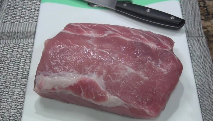 Lightly season the pork loin inside and out with salt and pepper. You can optionally stuff it with fillings like chopped fruit or dried fruit.