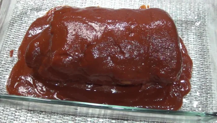 Transfer the pork loin to a preheated oven (340°F/170°C) and bake for approximately 40-45 minutes, basting occasionally with sauce to prevent drying.