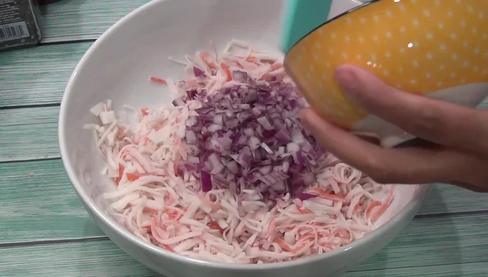 In a bowl, combine the chopped onion, green chilies, tomatoes, and surimi (cut into small pieces).