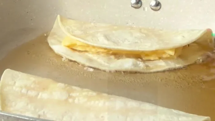 Fry the cheese-filled tortillas until golden brown and cheese is melted.