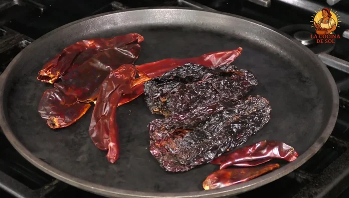 Toast guajillo and pua chiles until slightly browned, being careful not to burn them. Boil tomato in a pot of water for about 5 minutes. Add roasted chiles and continue boiling for 5 minutes. Remove from heat and let cool.