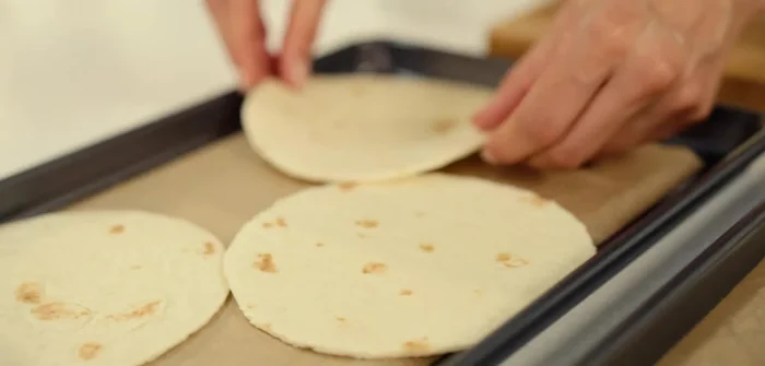 Place mini tortillas on a baking tray lined with baking paper. Brush with olive oil and bake until golden. Let them cool before serving.