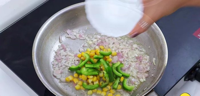 Add corn kernels, capsicum, and sauté for 1.5 minutes.