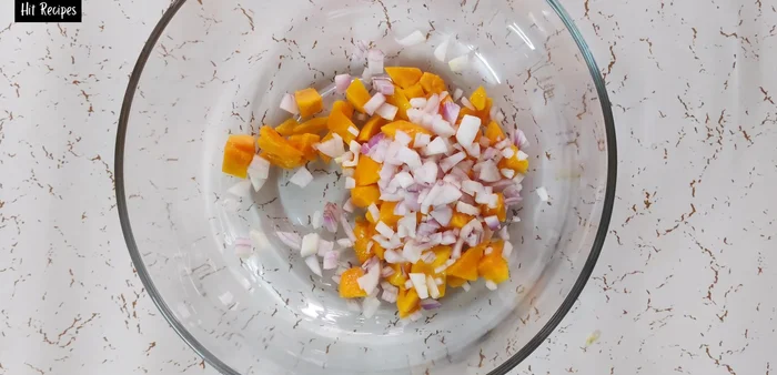 Finely chop a small onion, half a medium-sized capsicum, and a small green chili. Add to the mango.