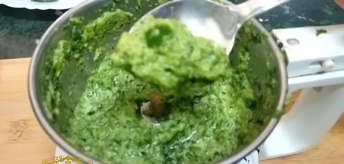 Crush the garlic, ginger, green chilies, basil, and coriander into a paste.