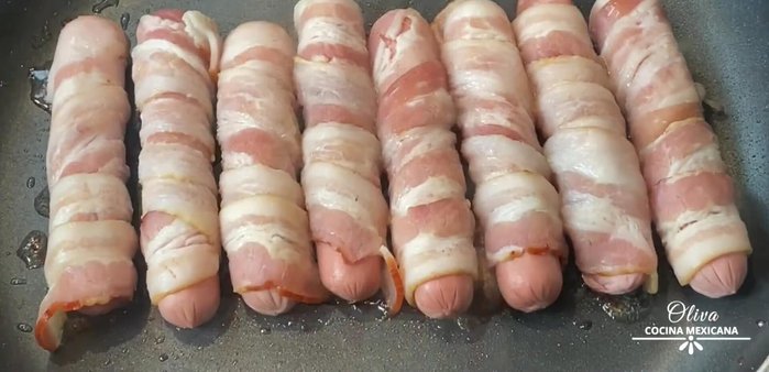 In a pan over medium heat, cook the bacon-wrapped sausages for 2 minutes per side, until well-browned.