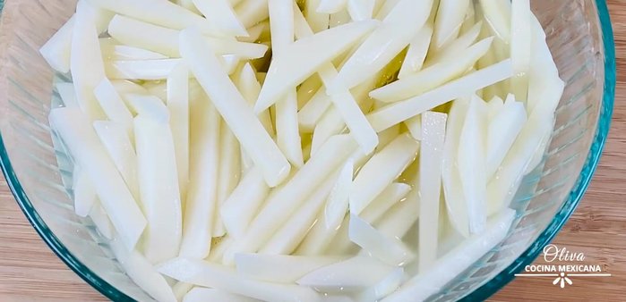 Prepare the potatoes by cutting them and adding water to prevent oxidation and remove the starch. You can fry them in a pan or deep fryer.