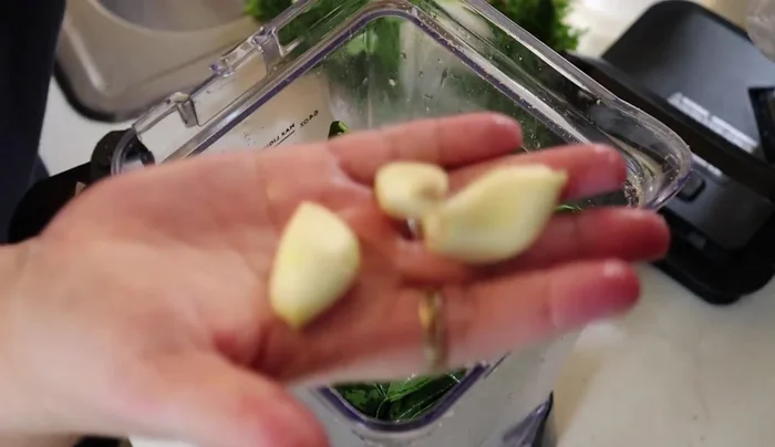 Blend spinach, 3 cloves garlic, 1/4 large onion, spring onions, and cilantro with water.