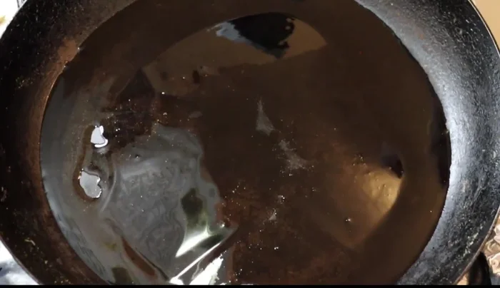 In the same pan used for toasting, fry the ground pepitas and peanuts with oil until they change color.