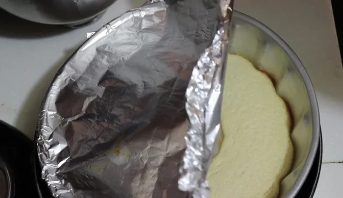 Once the flan is cooked, carefully remove it from the oven and let it cool slightly. Add the chocolate cake batter on top of the flan, covering about ¾ of the mold, leaving space for rising.