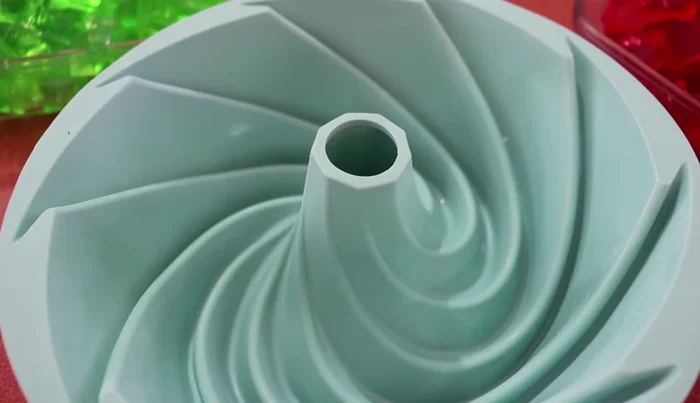 Layer the gelatins: Once the individual gelatins are set, chill the molds for at least 5 minutes. Layer the red, green, and three-milk gelatins in the chilled molds.
