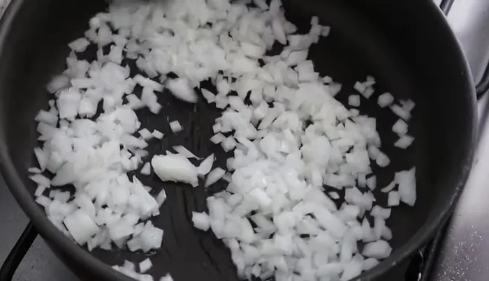 Add the shredded chicken to the pan and cook, seasoning with salt and garlic to taste.