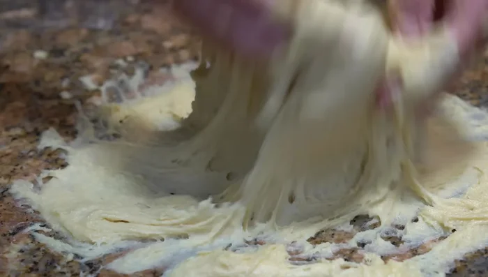 Knead the dough until it comes off the bowl. A stand mixer can be used.