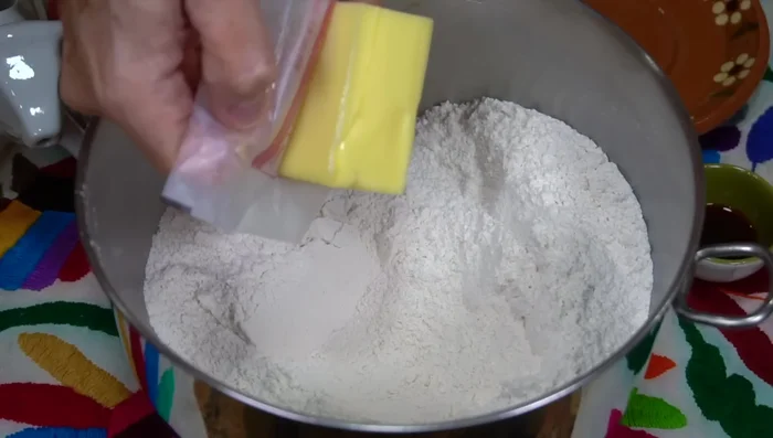 Add room temperature butter, cottage cheese, and vanilla extract to the flour mixture. Incorporate everything with clean hands until it resembles arenisca (sandy texture).