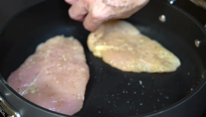 Cook chicken breasts in a separate pan over medium-high heat until lightly browned on both sides and cooked through.