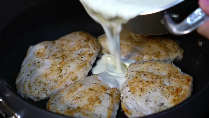 Add the warm cheese sauce to the chicken breasts, letting them finish cooking in the sauce.