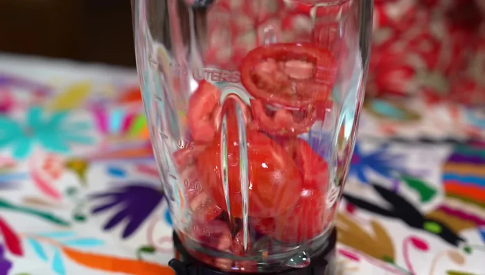 Prepare the sauce by blending ripe tomatoes, onion, garlic, cilantro, spices, and water in a blender or molcajete.