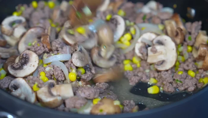 After 5 minutes, when mushrooms release their juice, pour in the prepared sauce. Season with salt and stir.