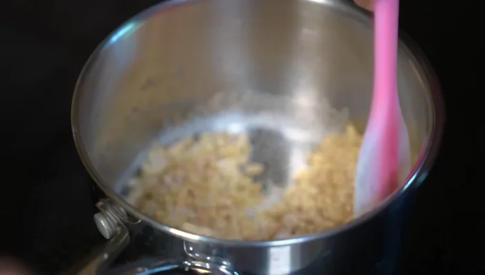 Return to medium-low heat, continue mixing until sugar caramelizes and rice is golden. Spread immediately onto a baking sheet.