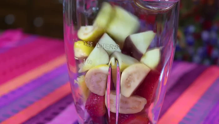 Strain the blended strawberries, guavas and apple pieces.