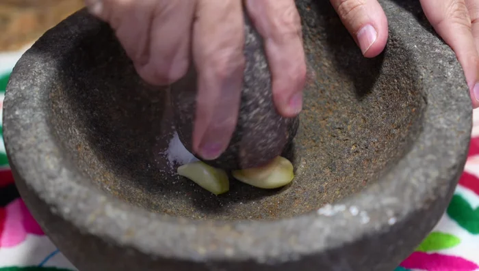 Prepare the marinade: In a mortar, combine garlic, salt, pepper, cumin, oregano, diluted lemon juice, and olive oil.