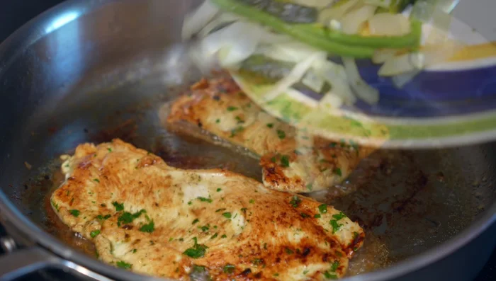 Combine chicken and chili mixture: Once the chicken is browned, add the sautéed onion and chili mixture to the pan, allowing the chicken to absorb the flavors.