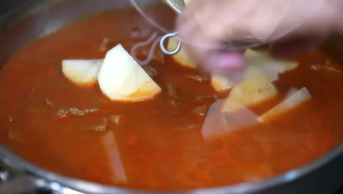 After 20 minutes of cooking, add the potatoes, season with salt, cover, and let it finish cooking.