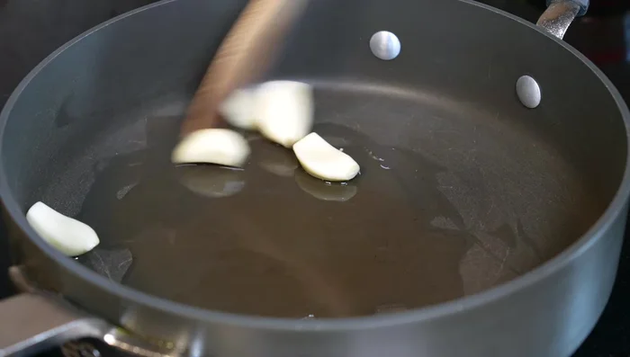 In a pan with hot oil, sauté garlic until golden, then add onions. When almost golden, add dried chipotle chile, then guajillo chiles.