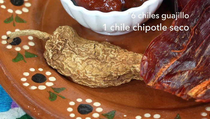 Prepare the marinade: Clean and deseed the chiles. In a molcajete, grind cumin, oregano, cloves, allspice, and black pepper.