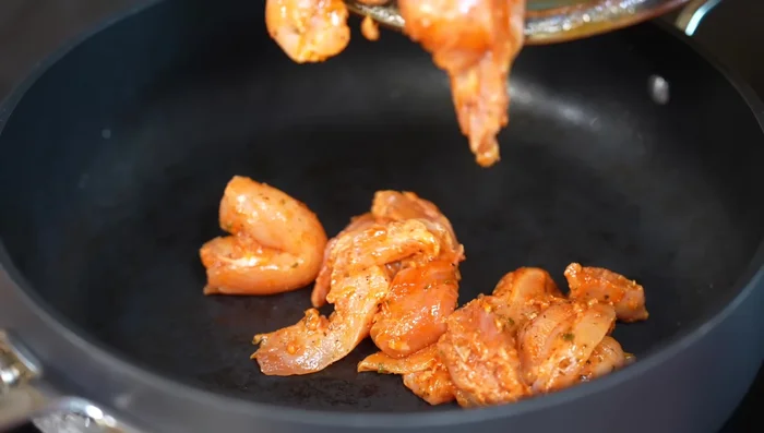 Add marinated chicken to the pan and cook until browned on both sides.